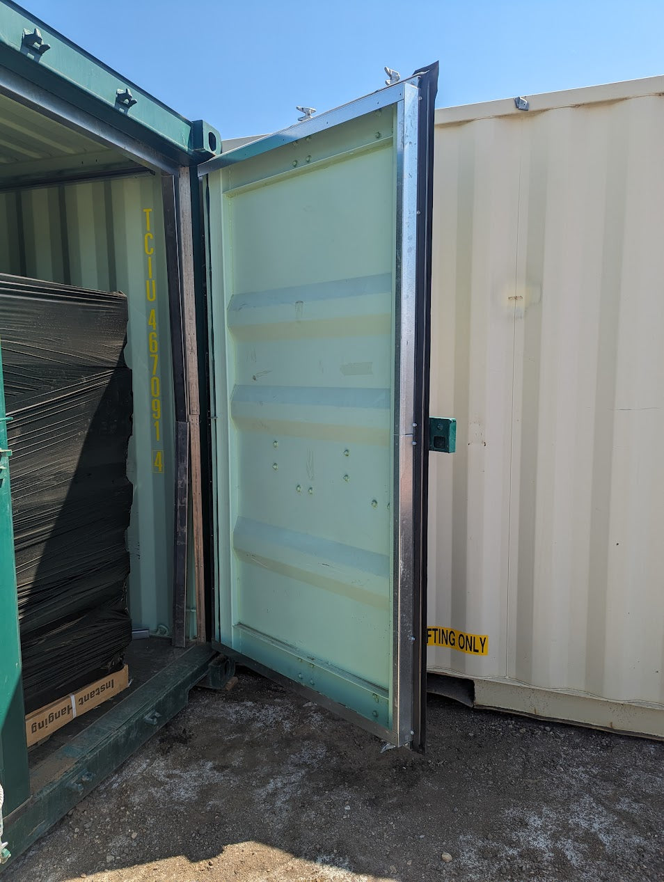 Installed container door flashing kit on a green shipping container door, showcasing a clean galvanized steel finish with secure fit around the door frame