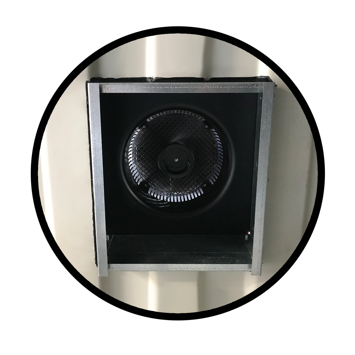 Interior view of a solar-powered exhaust fan mounted inside a shipping container wall, featuring a protective grille and custom framing for ventilation