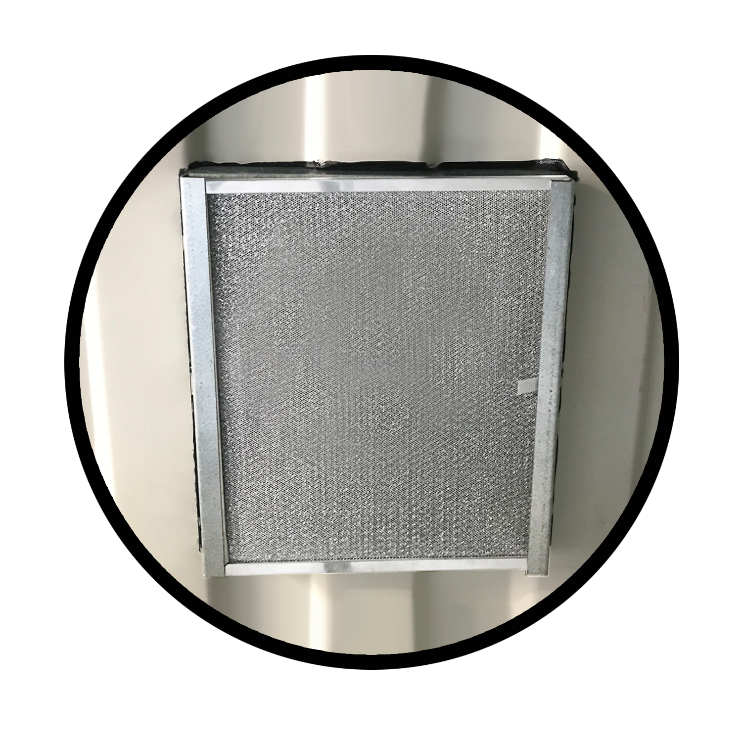 Close-up interior view of a removable aluminum bug filter installed inside a shipping container wall, framed with a square metal trim